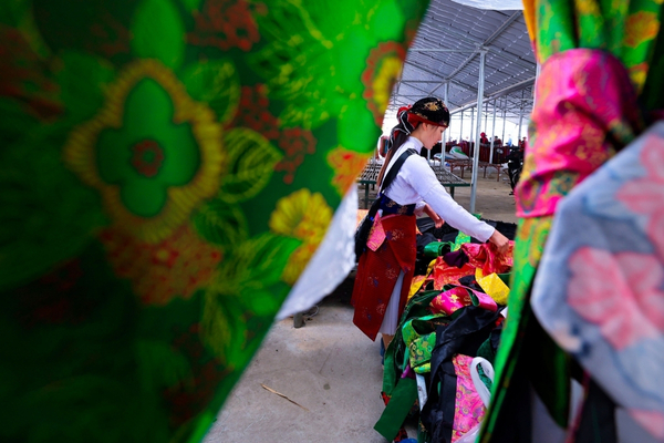 Authentic highland market experience with diverse clothing and fabrics in Ha Giang