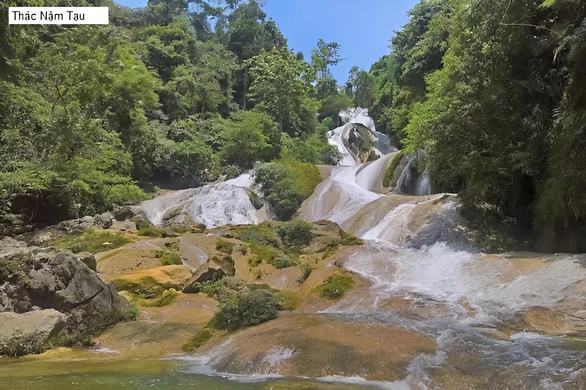 Nam Tau Waterfall surrounded by lush greenery and hidden caves in Bac Quang District
